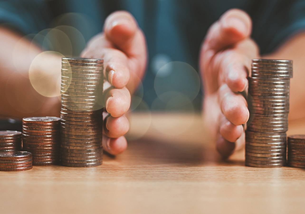 Info: Fundos de Distribuição de Rendimento. Mãos masculinas que separam 2 séries de colunas de moedas.