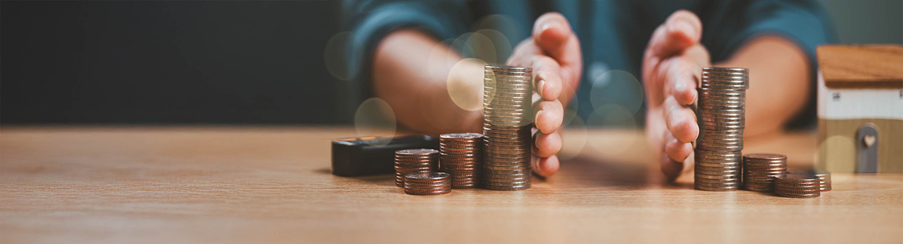 Info: Fundos de Distribuição de Rendimento. Mãos masculinas que separam 2 séries de colunas de moedas.