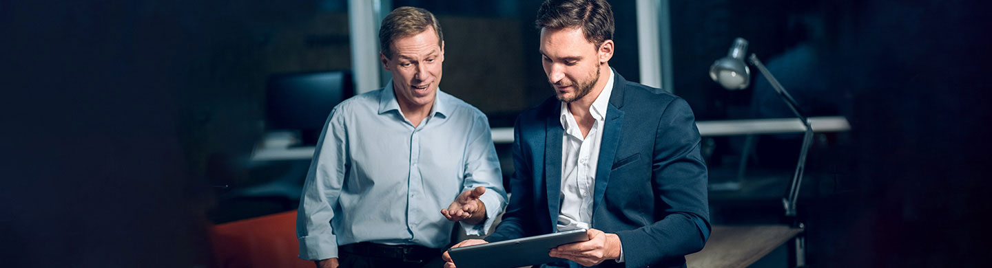 Dois homens portugueses com um tablet a conhecer as vantagens do fundo BPI Obrigações 2026.