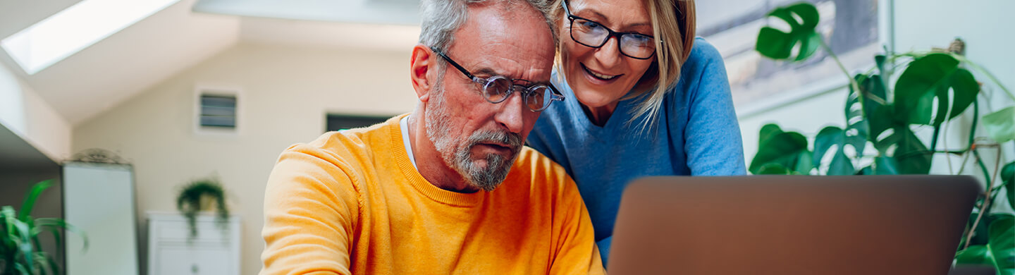 Pareja mirando la pantalla de un portátil. Soluciones BPI Particulares.