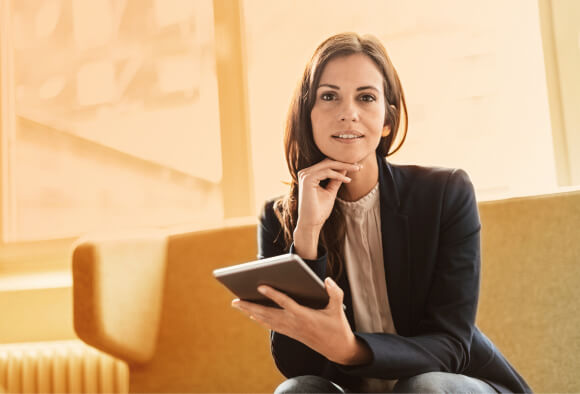 Mujer sonriente sentada en una habitación. Productos Estructurados BPI.